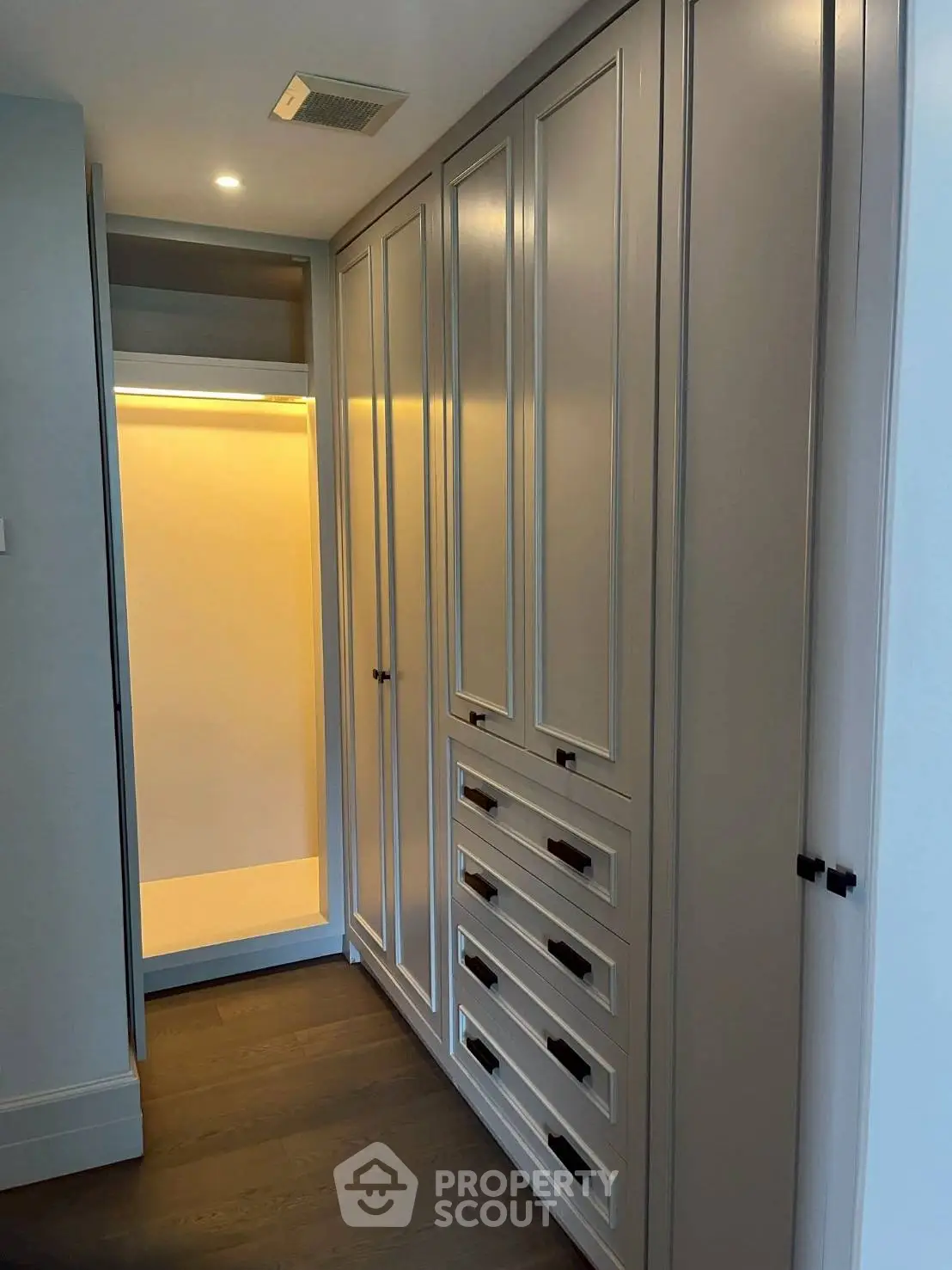 Elegant walk-in closet with custom cabinetry and ambient lighting