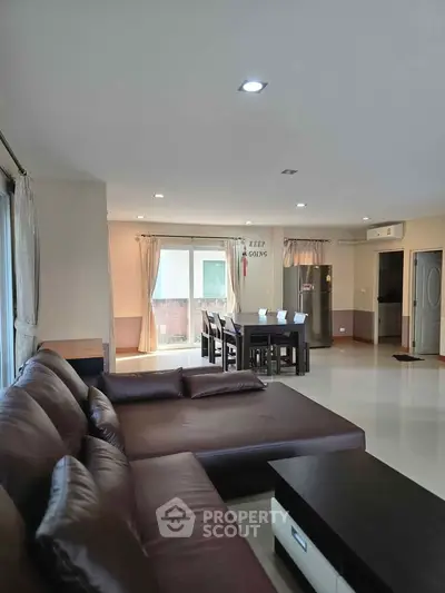 Spacious living room with modern furniture and ample natural light, perfect for relaxation and entertainment.