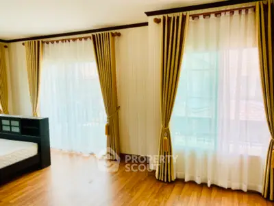 Spacious bedroom with elegant curtains and wooden flooring