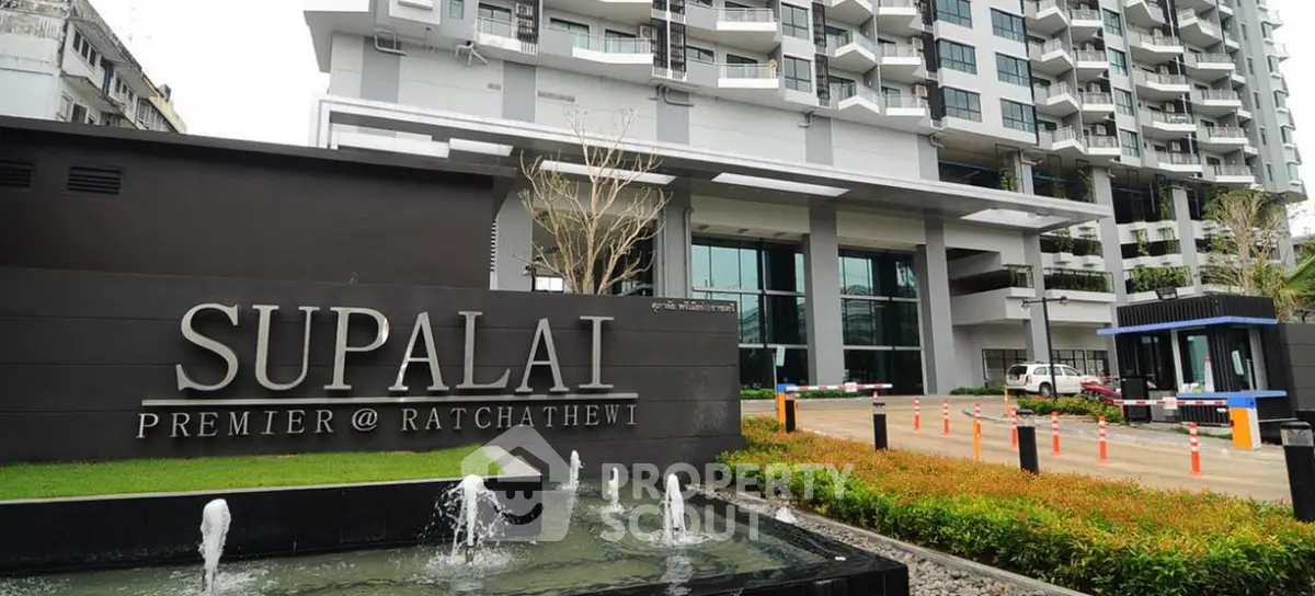 Modern condominium entrance with sleek design and lush landscaping.