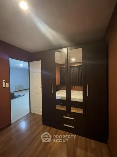 Spacious bedroom with elegant wardrobe and wooden flooring