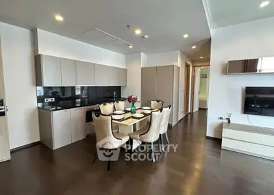 Modern open-layout kitchen and dining area with sleek cabinetry and elegant dining set.