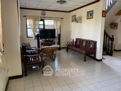 Spacious living room with traditional wooden furniture and tiled flooring