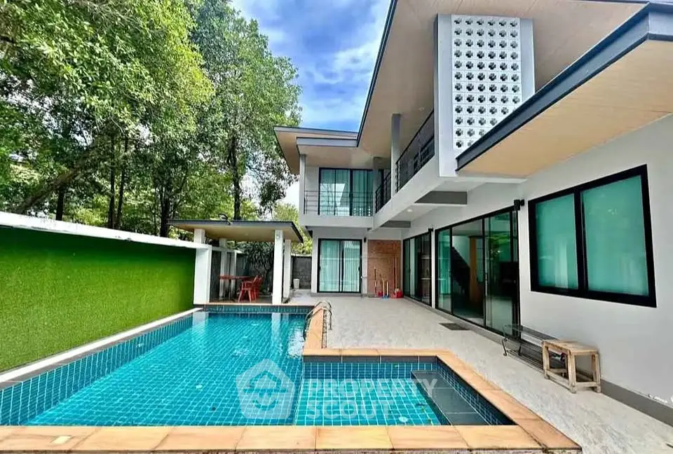 Modern two-story house with private pool and lush greenery