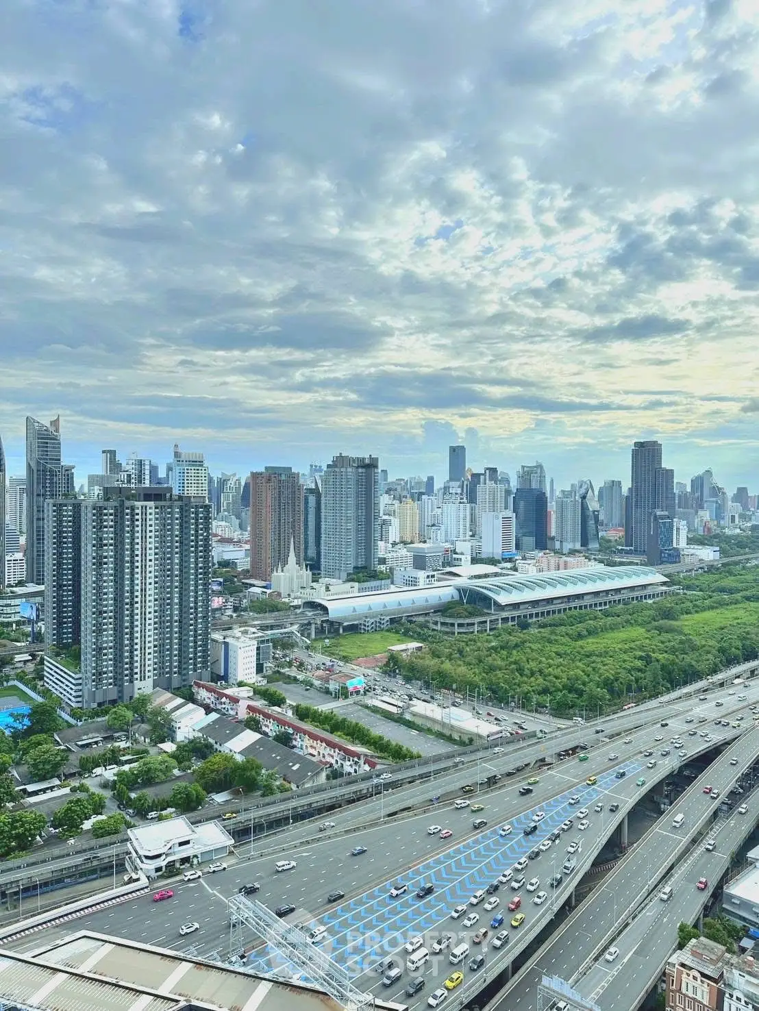 Stunning cityscape view with modern skyscrapers and bustling highway, perfect for urban living enthusiasts.