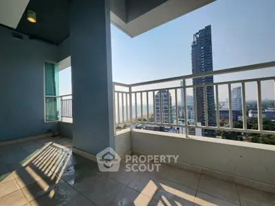 Spacious balcony with stunning city and ocean views in a high-rise building.