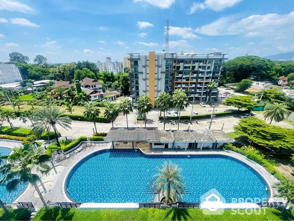 Stunning apartment complex with a large swimming pool and lush greenery, perfect for luxury living.