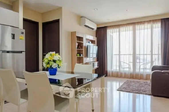 Modern living room with dining area and balcony access in a stylish apartment.
