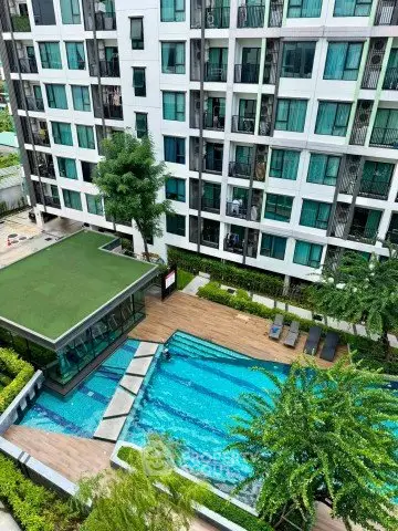Modern apartment complex with a stunning outdoor pool and lush greenery, perfect for urban living.