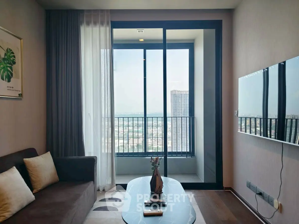 Modern living room with balcony and stunning city view, featuring sleek furniture and elegant decor.
