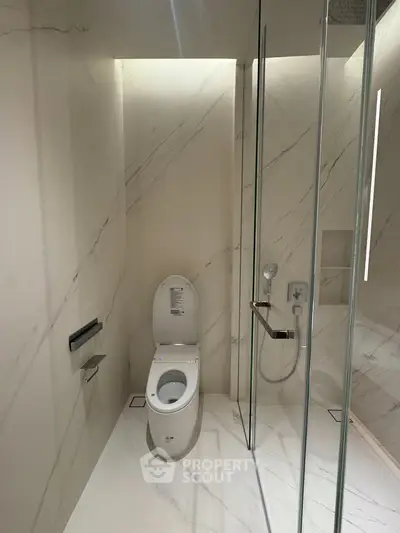 Luxurious modern bathroom with sleek marble design and glass shower enclosure.