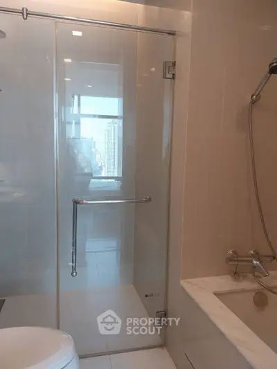 Modern bathroom with glass shower and city view