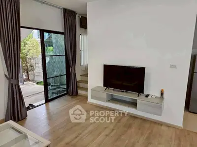 Modern living room with sleek TV setup and large window view