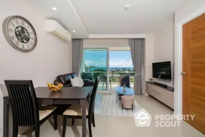 Modern living room with ocean view, stylish furniture, and open balcony access.