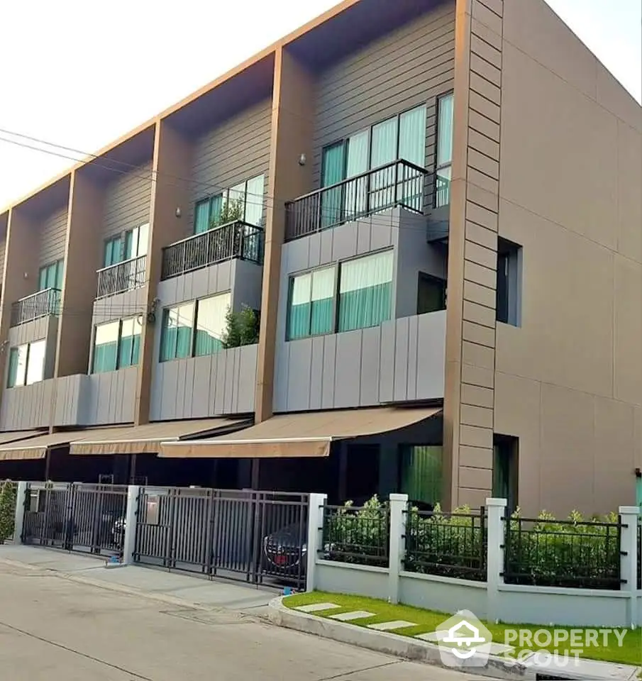 Modern townhouse exterior with sleek design and spacious balconies in a serene neighborhood.