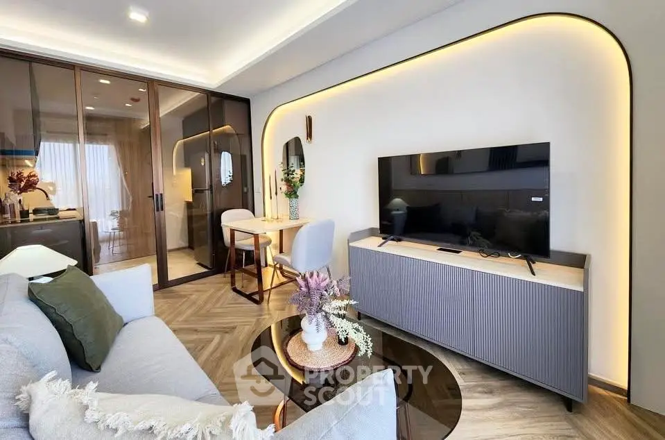 Modern living room with stylish decor and open layout, featuring a sleek TV unit and elegant lighting.