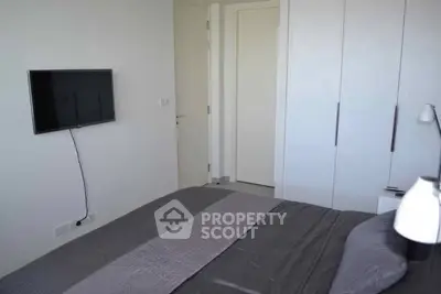 Modern bedroom with sleek design and wall-mounted TV in a stylish apartment.