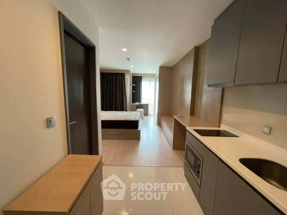 Modern studio apartment with compact kitchen and cozy bedroom area