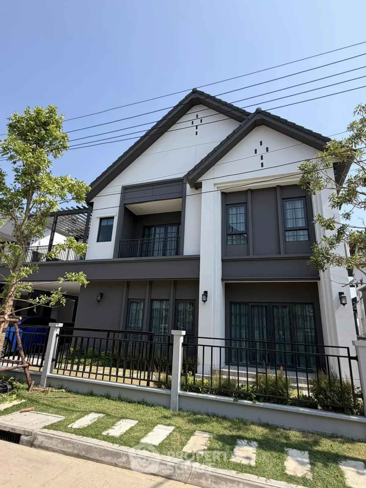 Modern two-story house with stylish facade and lush garden in a serene neighborhood.