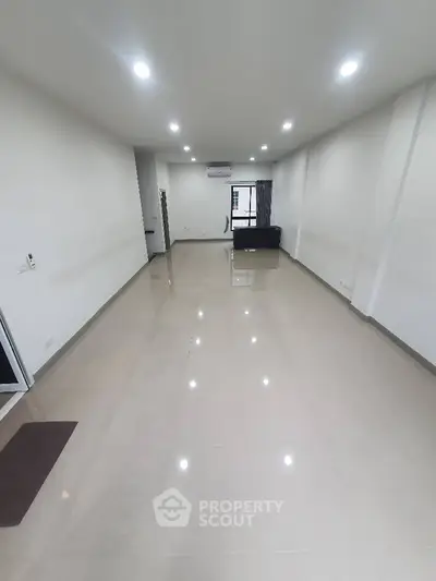 Spacious modern living room with sleek flooring and ample lighting