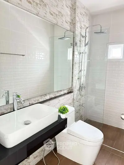 Modern bathroom with sleek fixtures and glass shower enclosure