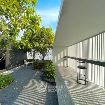 Modern outdoor terrace with sleek bar seating and lush greenery