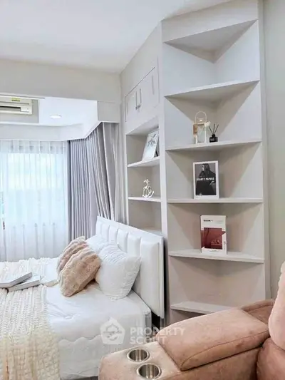 Cozy bedroom with modern shelving and plush bedding in a stylish apartment.