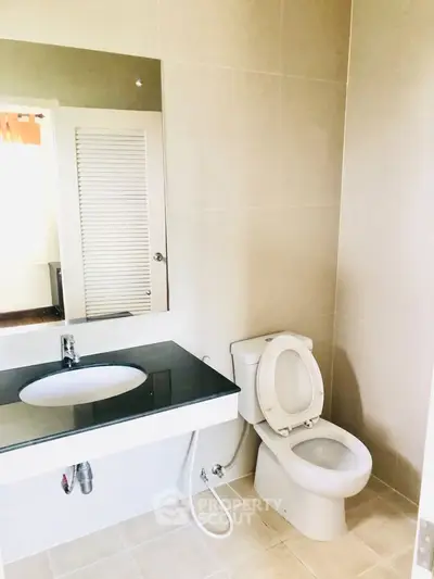 Modern bathroom with sleek sink and toilet in a minimalist design.