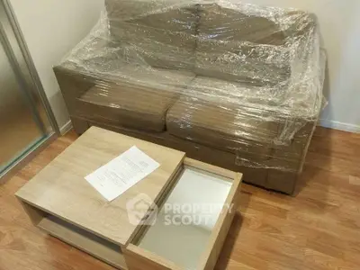 Modern living room with wrapped sofa and wooden coffee table on polished floor.