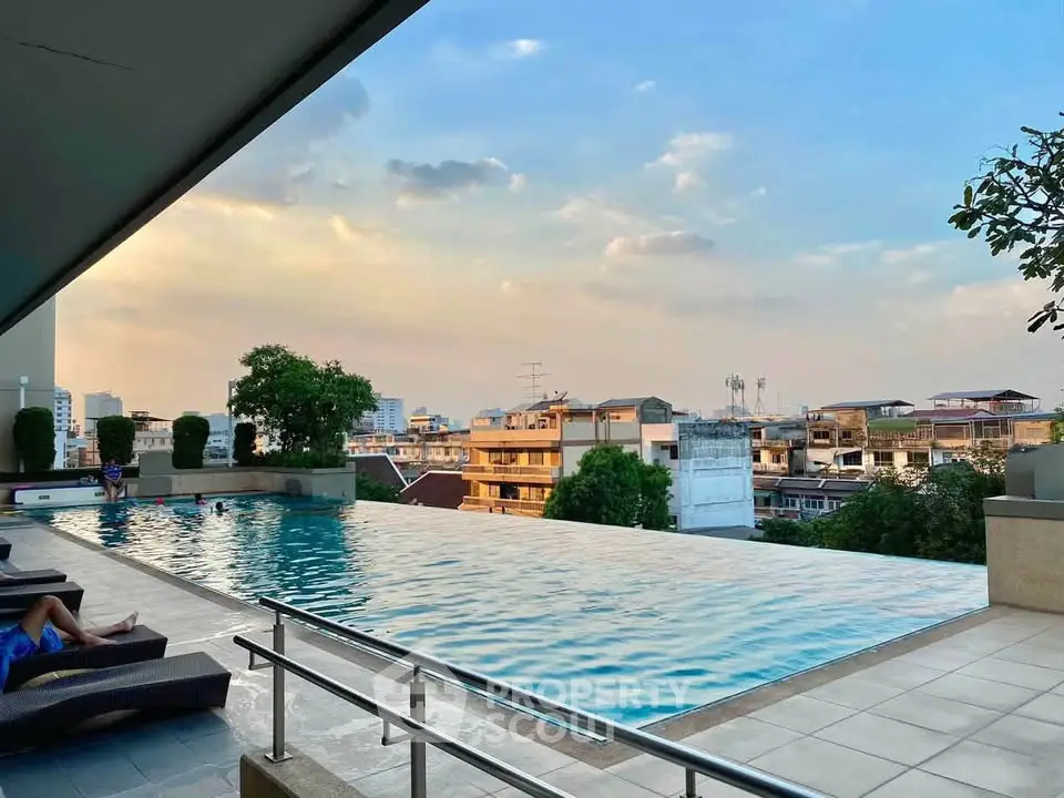 Luxurious rooftop infinity pool with stunning city views at sunset, perfect for relaxation and leisure.