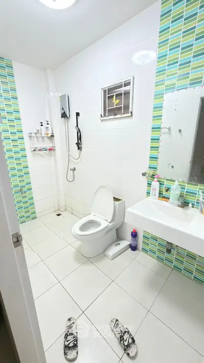 Spacious modern bathroom with vibrant tile accents and sleek fixtures.