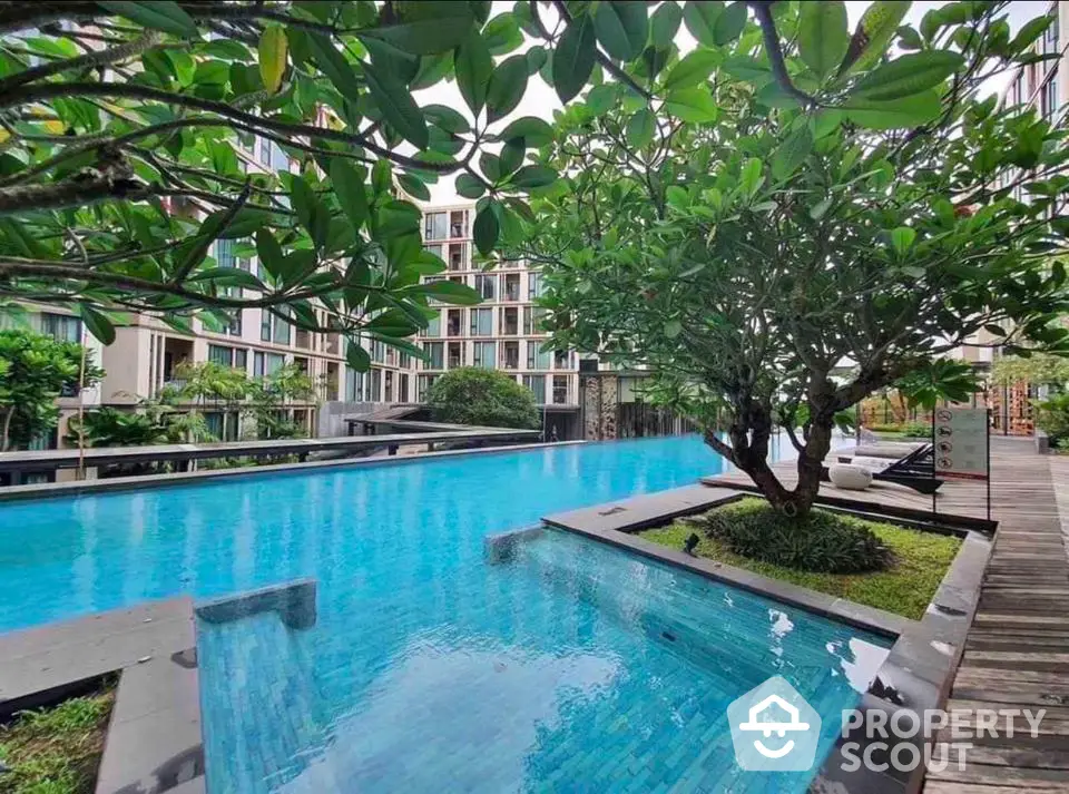 Luxurious condominium pool area with lush greenery and modern design