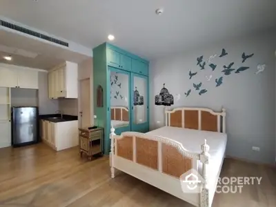 Charming bedroom with stylish decor and compact kitchen area, perfect for modern living.