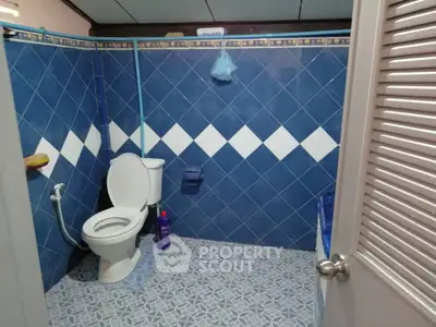 Charming blue-tiled bathroom with modern fixtures and cozy ambiance.