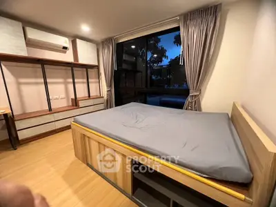 Spacious bedroom with modern design and large window offering serene views.