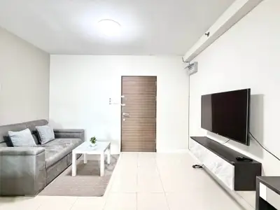 Modern living room with sleek furniture and wall-mounted TV, perfect for relaxation and entertainment.