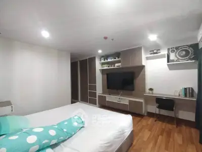 Modern bedroom with stylish decor and built-in entertainment unit