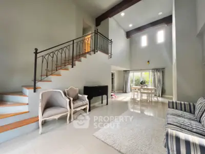 Spacious living room with high ceilings and elegant staircase in modern home