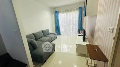 Modern living room with sleek gray sofa and large window with blue curtains.