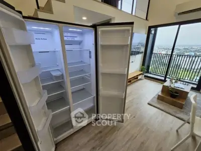 Spacious modern living room with open kitchen and large balcony view