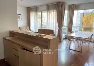 Spacious living room with elegant wooden flooring and large windows for natural light.