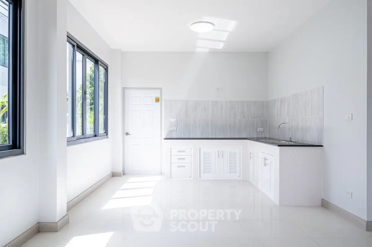 Bright minimalist kitchen with large windows and sleek cabinetry