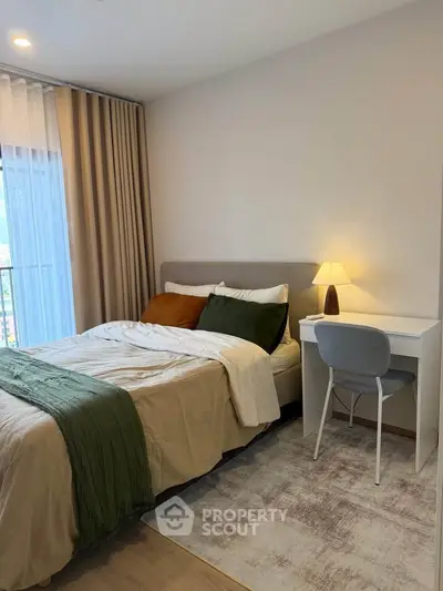 Cozy bedroom with modern decor, featuring a comfortable bed and a stylish desk, perfect for relaxation and work.