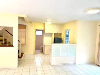Spacious open-plan living area with modern kitchen and staircase