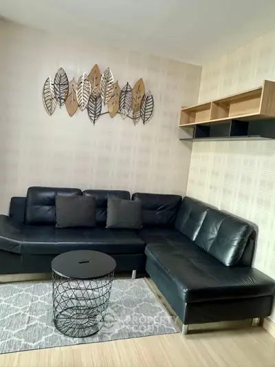 Modern living room with stylish black leather sofa and decorative wall art