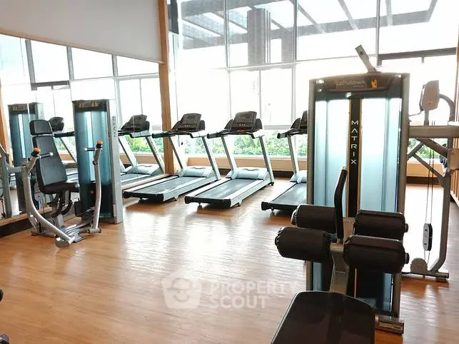Modern gym with state-of-the-art fitness equipment and large windows for natural light.