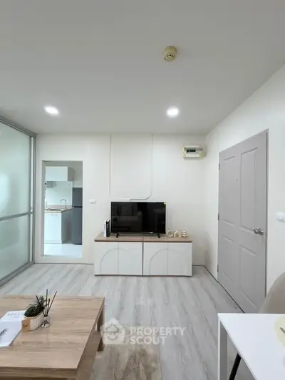 Modern living room with sleek design and natural light, featuring a TV unit and stylish furniture.