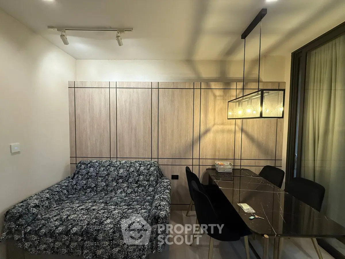 Modern dining area with elegant lighting and cozy seating in a stylish apartment.