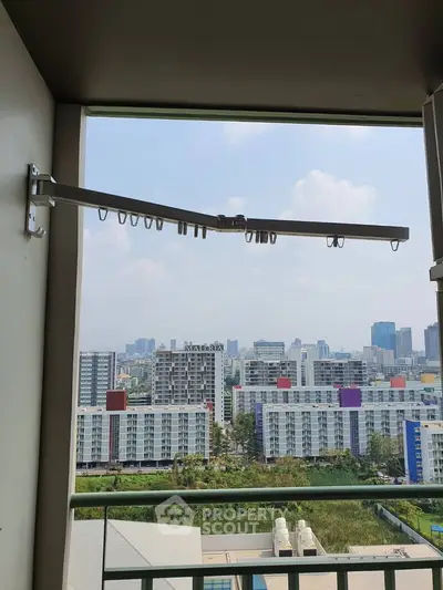 Stunning cityscape view from a high-rise balcony with modern railing and clothes drying rack.