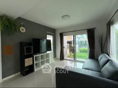 Modern living room with sleek furniture and large windows overlooking a garden.